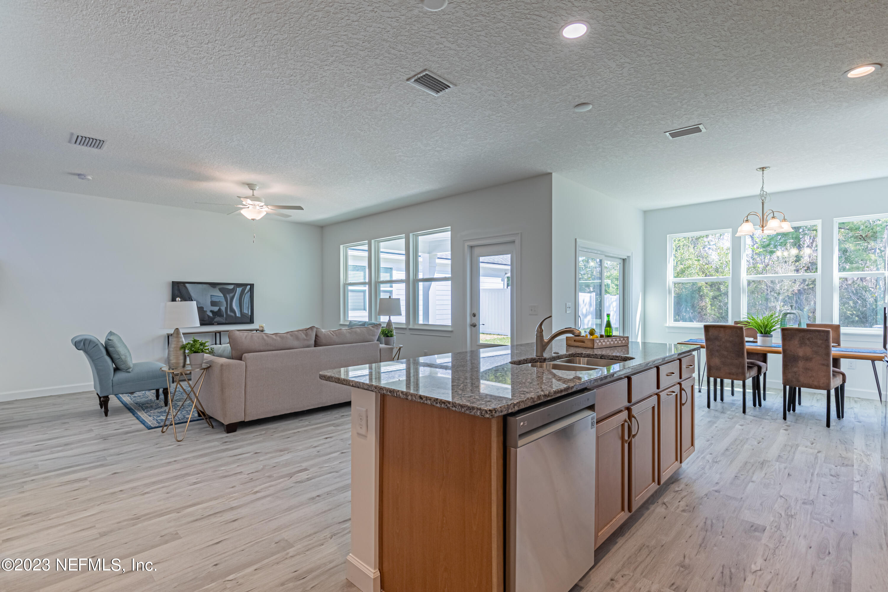 3093 Orange Picker Road Jacksonville, FL 32223 - Photo 20 of 39 a kitchen with granite countertop a stove a sink a dining table and chairs with wooden floor
