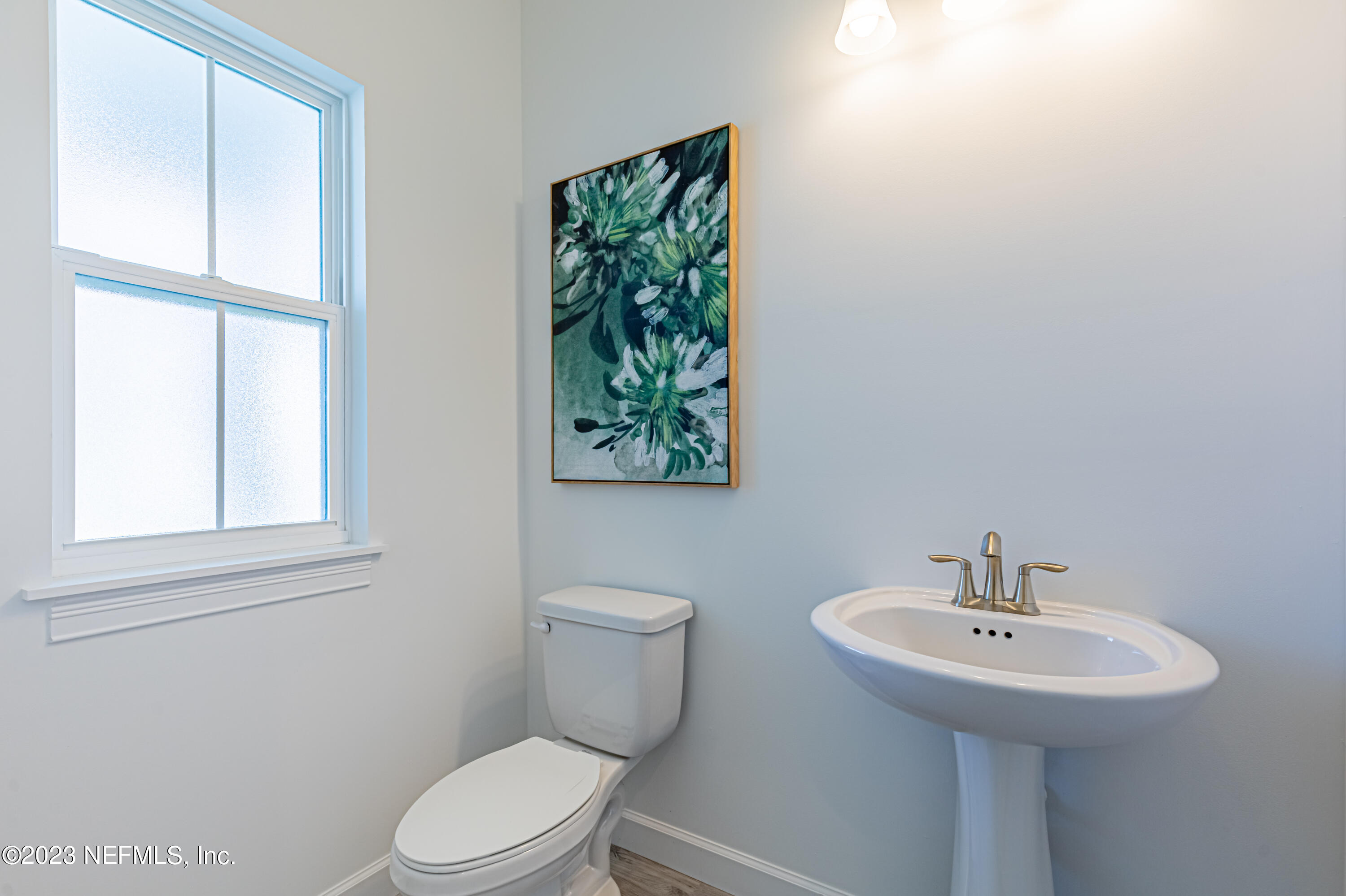 3093 Orange Picker Road Jacksonville, FL 32223 - Photo 5 of 39 a bathroom with a sink a toilet and a window
