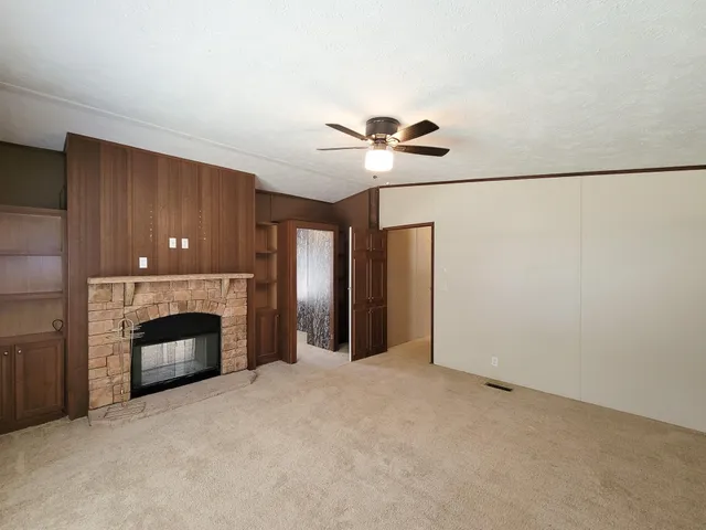 an empty room with windows and fireplace