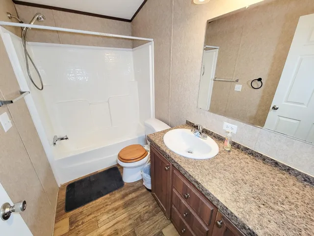 a bathroom with a granite countertop sink toilet and shower