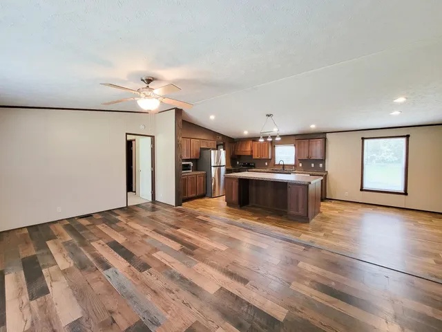 a view of a house with a ceiling fan and wooden floor