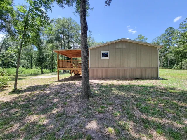 a view of a house with backyard and a tree