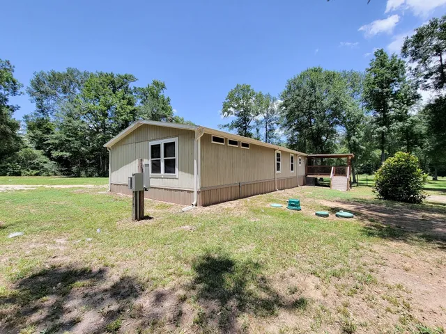 a view of a house with a yard and sitting area