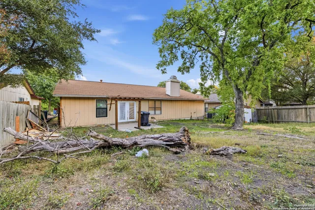 a backyard of a house with barbeque oven table and chairs