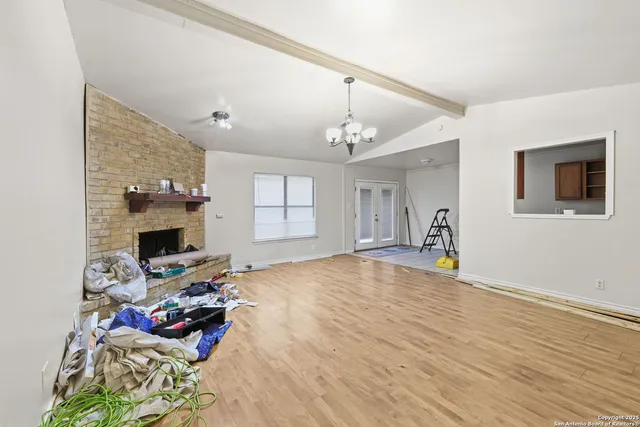 a view of a livingroom with wooden floor and a fireplace