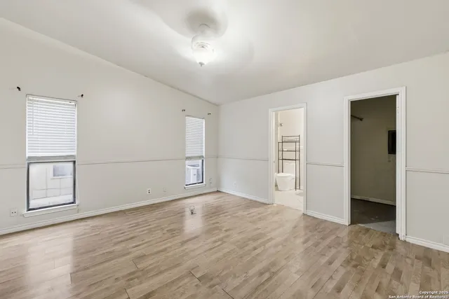 an empty room with wooden floor and cabinet
