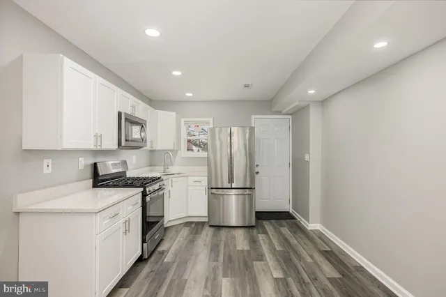a kitchen with a refrigerator stove and white cabinets