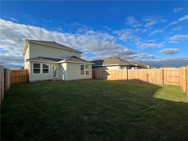 a view of a house with a backyard