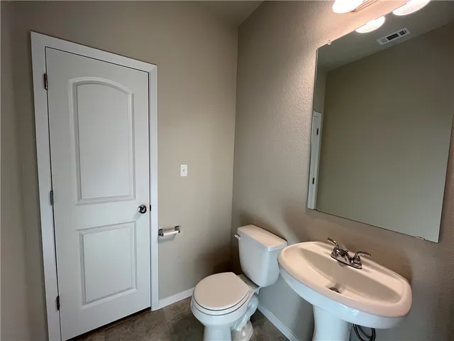 a bathroom with a toilet a sink and mirror
