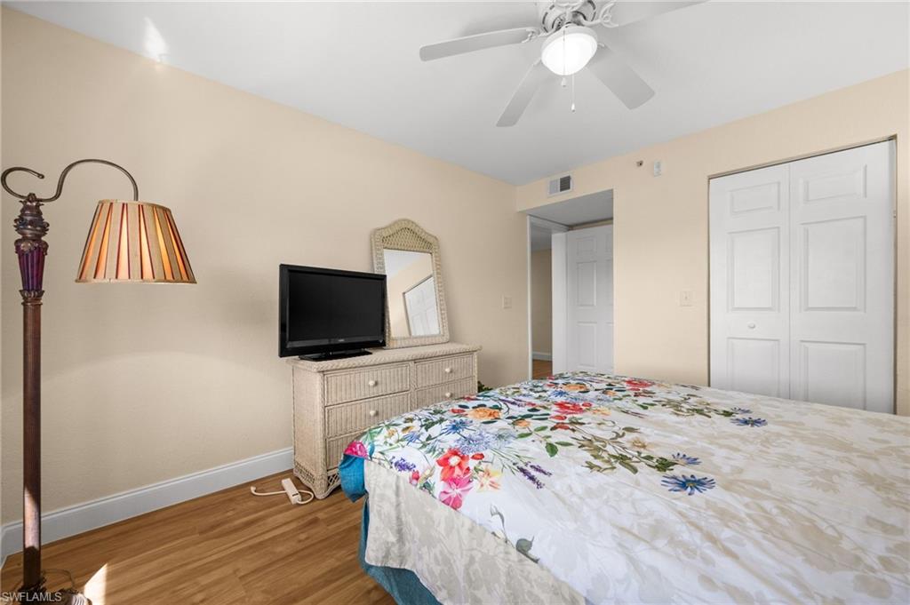 8264 Key Royal Circle, Unit 812 Naples, FL 34119 - Photo 17 of 21 Bedroom with light wood-style flooring, ceiling fan, and a closet