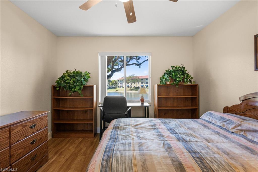 8264 Key Royal Circle, Unit 812 Naples, FL 34119 - Photo 19 of 21 Bedroom featuring wood finished floors, ceiling fan, and a water view