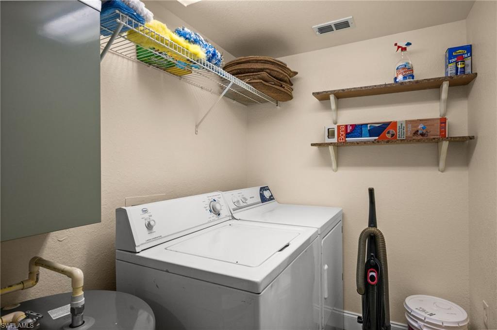 8264 Key Royal Circle, Unit 812 Naples, FL 34119 - Photo 21 of 21 Laundry area featuring a textured wall and washing machine and clothes dryer