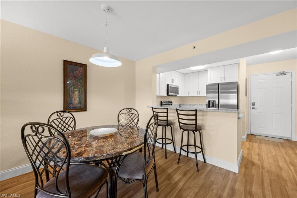 8264 Key Royal Circle, Unit 812 Naples, FL 34119 - Photo 8 of 21 Dining room with light wood-style flooring and baseboards