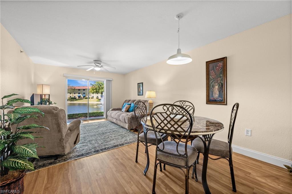 8264 Key Royal Circle, Unit 812 Naples, FL 34119 - Photo 9 of 21 Dining room with wood finished floors, a ceiling fan, and a water view