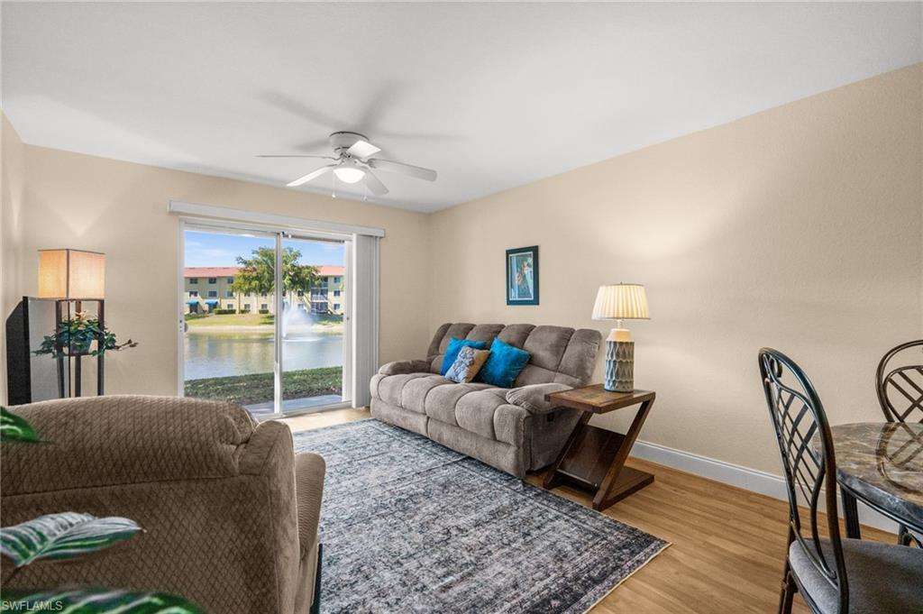 8264 Key Royal Circle, Unit 812 Naples, FL 34119 - Photo 10 of 21 Living area featuring ceiling fan, light wood-style flooring, and a water view