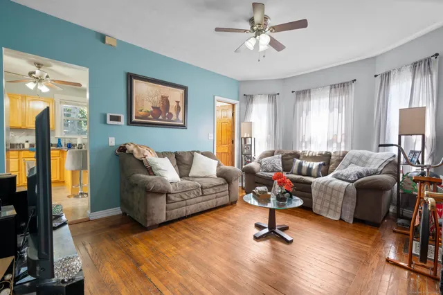 a living room with furniture ceiling fan and a window