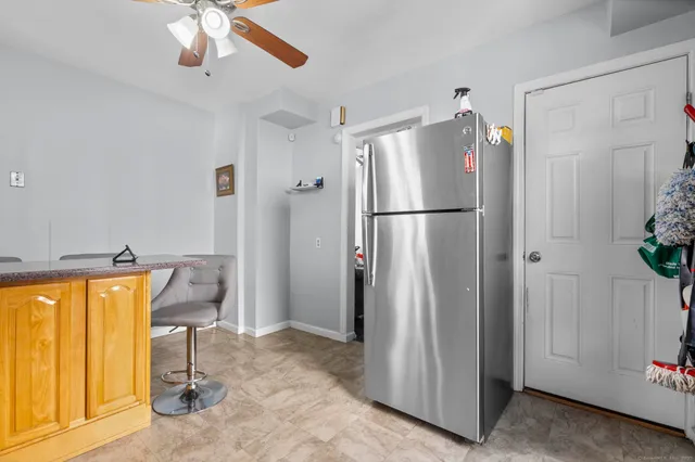 a view of a refrigerator and wooden floor in a room