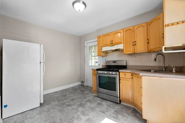 a kitchen with stainless steel appliances granite countertop a stove a sink and a refrigerator with cabinets