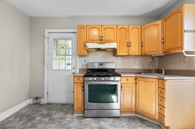 a kitchen with a stove a sink and a window