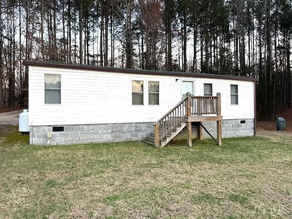 a view of a house with a yard and sitting area