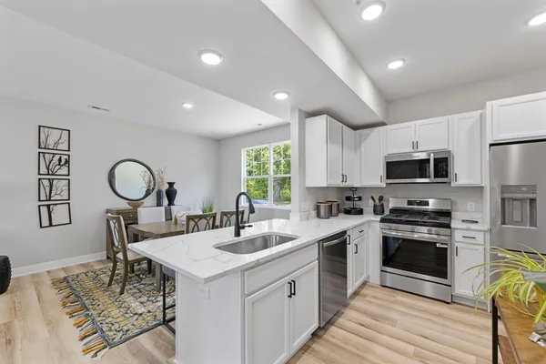 a kitchen with a stove a sink a microwave and cabinets