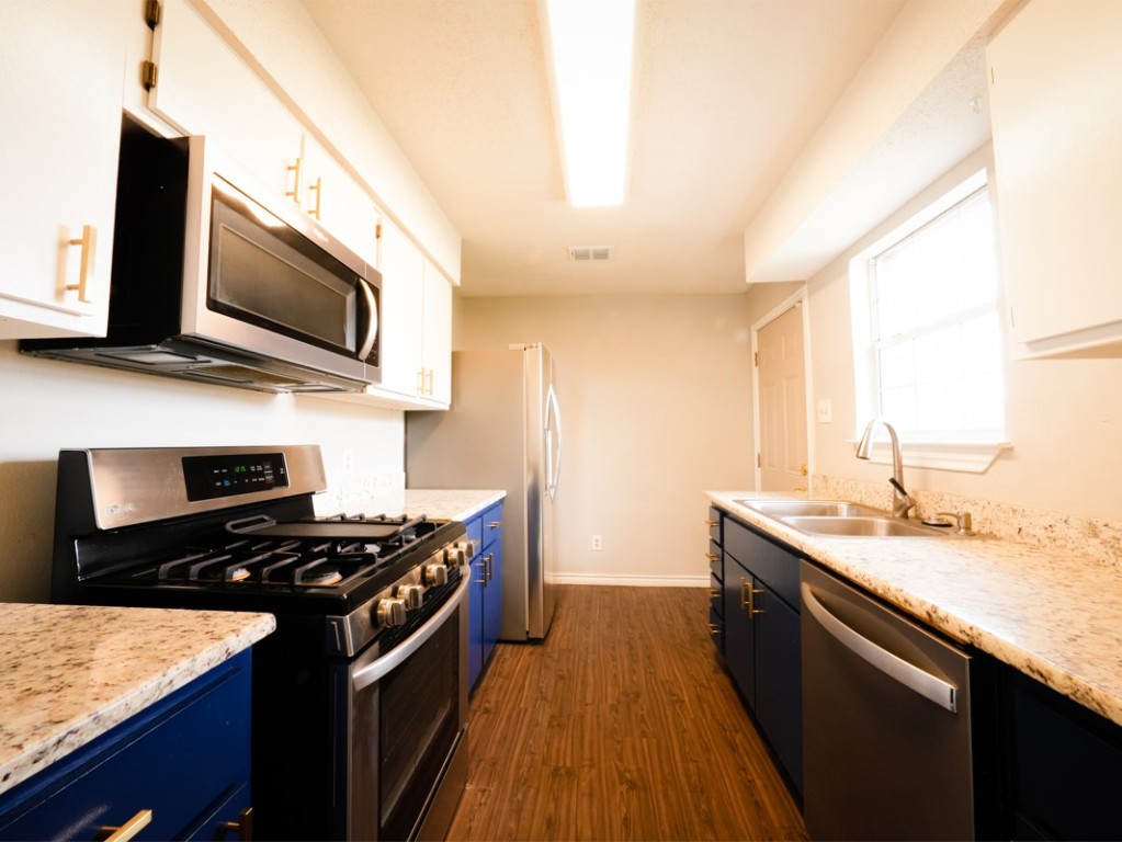 7312 Providence Avenue Austin, TX 78752 - Photo 4 of 22 a kitchen with stainless steel appliances granite countertop a stove a sink and a microwave