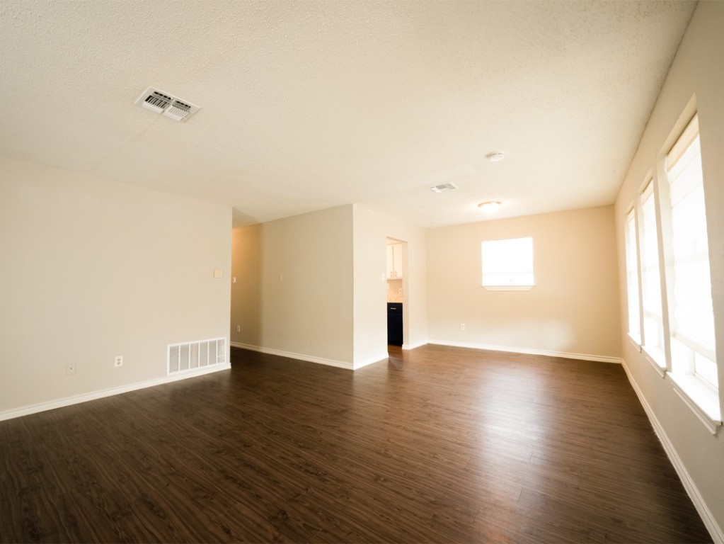 7312 Providence Avenue Austin, TX 78752 - Photo 7 of 22 a view of an empty room with wooden floor and a window