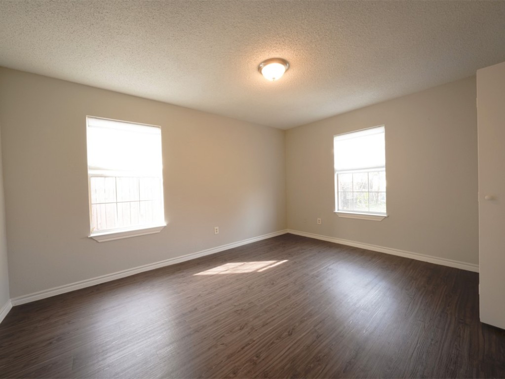 7312 Providence Avenue Austin, TX 78752 - Photo 8 of 22 an empty room with wooden floor and windows