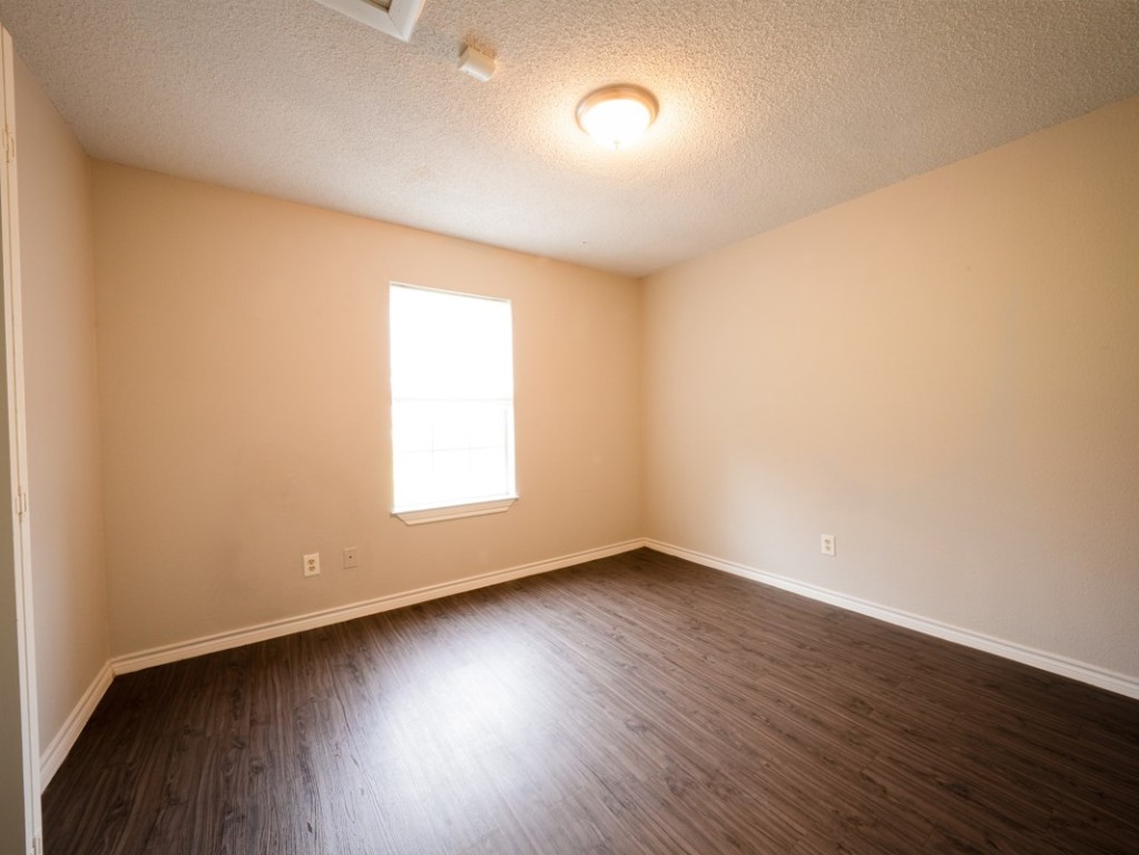 7312 Providence Avenue Austin, TX 78752 - Photo 10 of 22 an empty room with wooden floor and windows