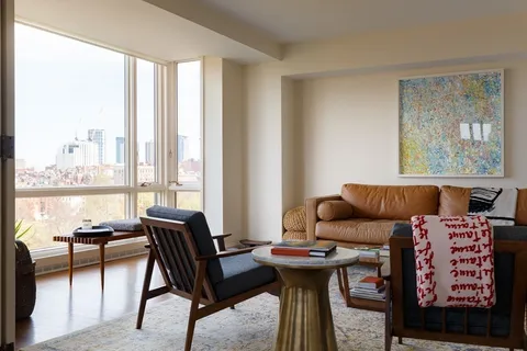 a living room with furniture and a floor to ceiling window