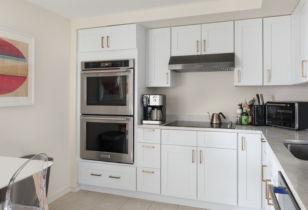 2 Commonwealth Avenue, Unit 8G Boston, MA 02116 - Photo 8 of 20 a kitchen with white cabinets and appliances