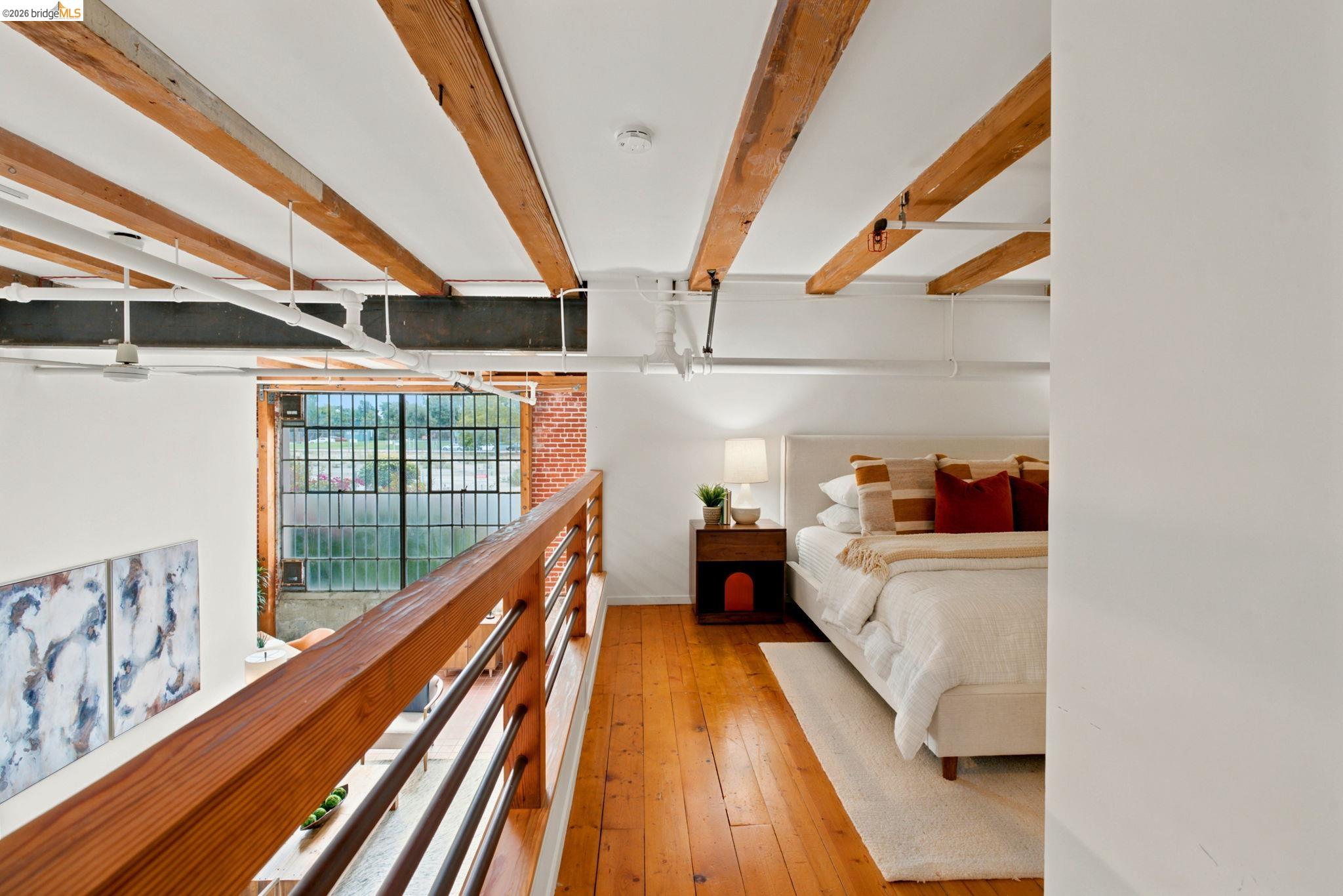 1920 Union Street, Unit 9 Oakland, CA 94607 - Photo 19 of 35 Open-concept loft bedroom featuring exposed ceiling beams and wood-finish flooring