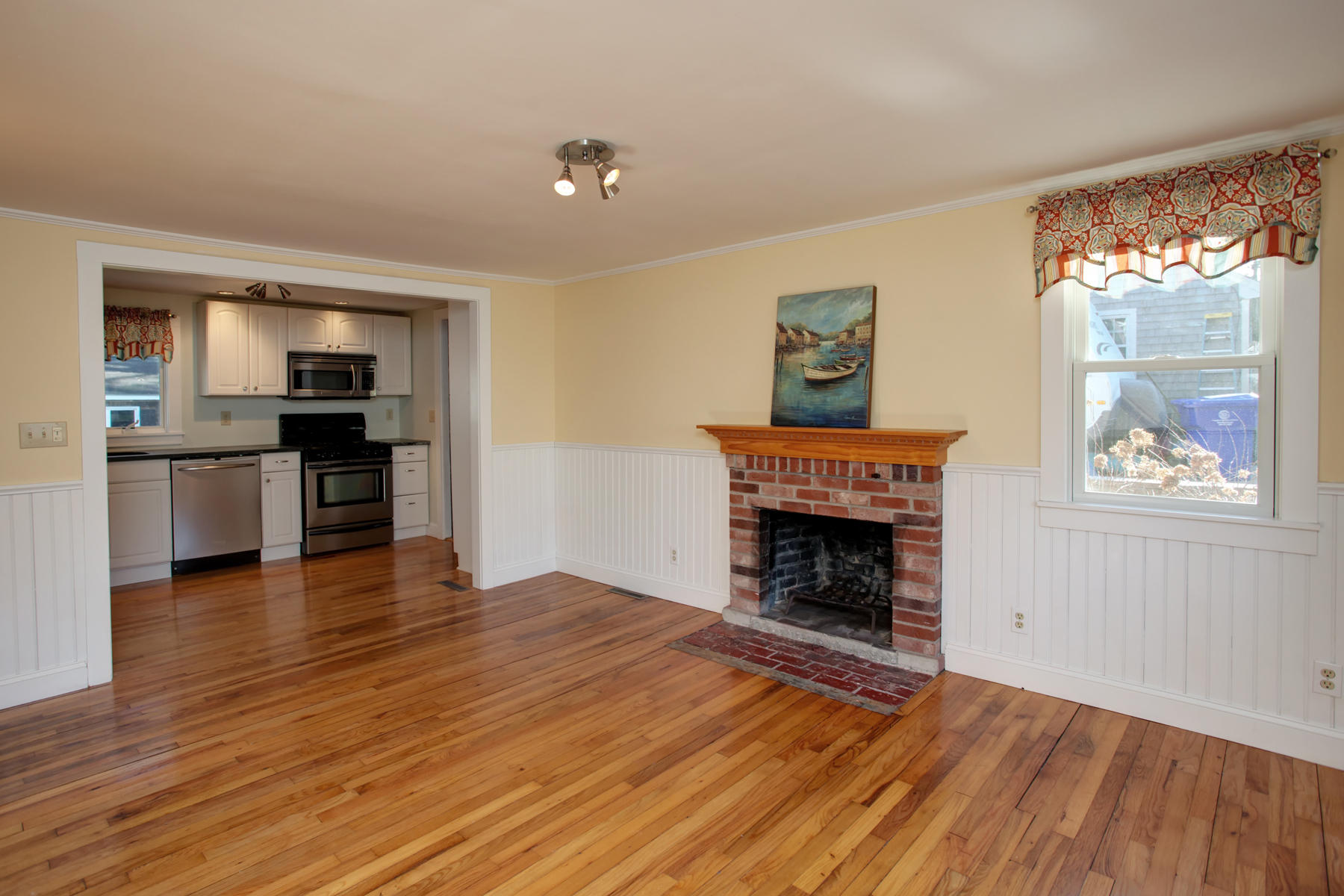 46 Thorne Road Bourne, MA 02532 - Photo 17 of 32 an empty room with wooden floor fireplace and windows