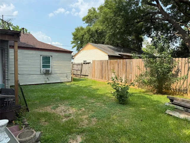 a view of a backyard with table and chairs and potted plants