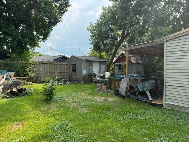 a view of a chair and table in backyard of the house