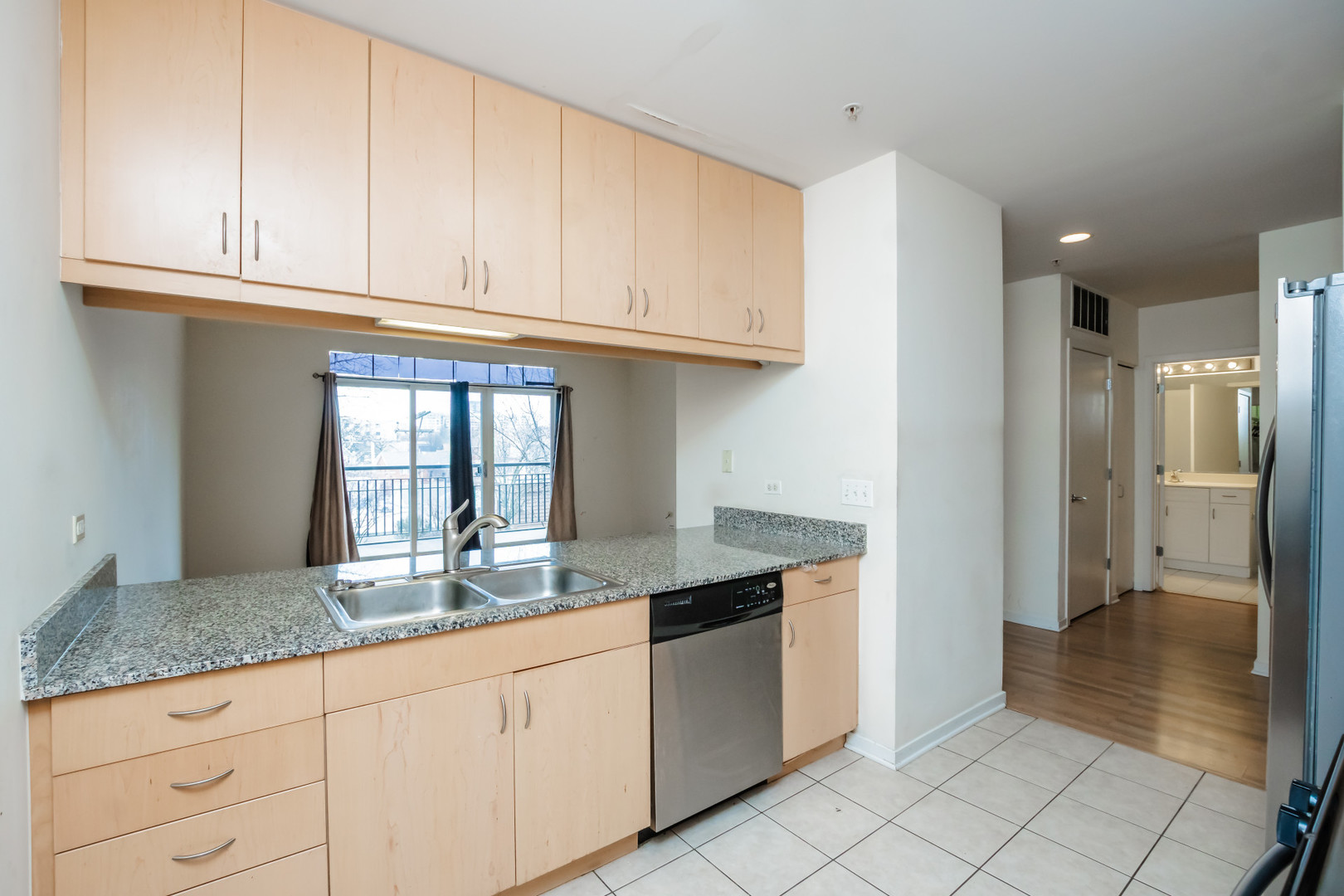 7243 Madison Street, Unit 310 Forest Park, IL 60130 - Photo 6 of 23 a kitchen with granite countertop a sink stainless steel appliances and cabinets