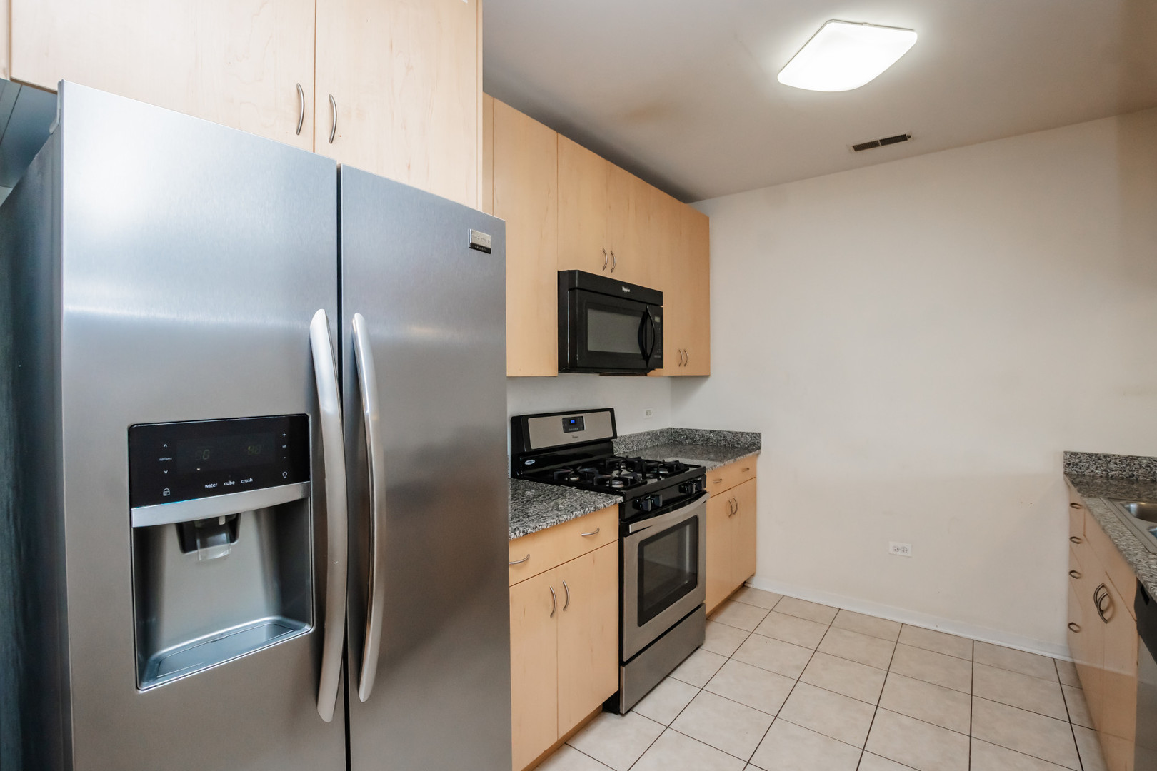 7243 Madison Street, Unit 310 Forest Park, IL 60130 - Photo 7 of 23 a kitchen with stainless steel appliances granite countertop a refrigerator a stove and a sink