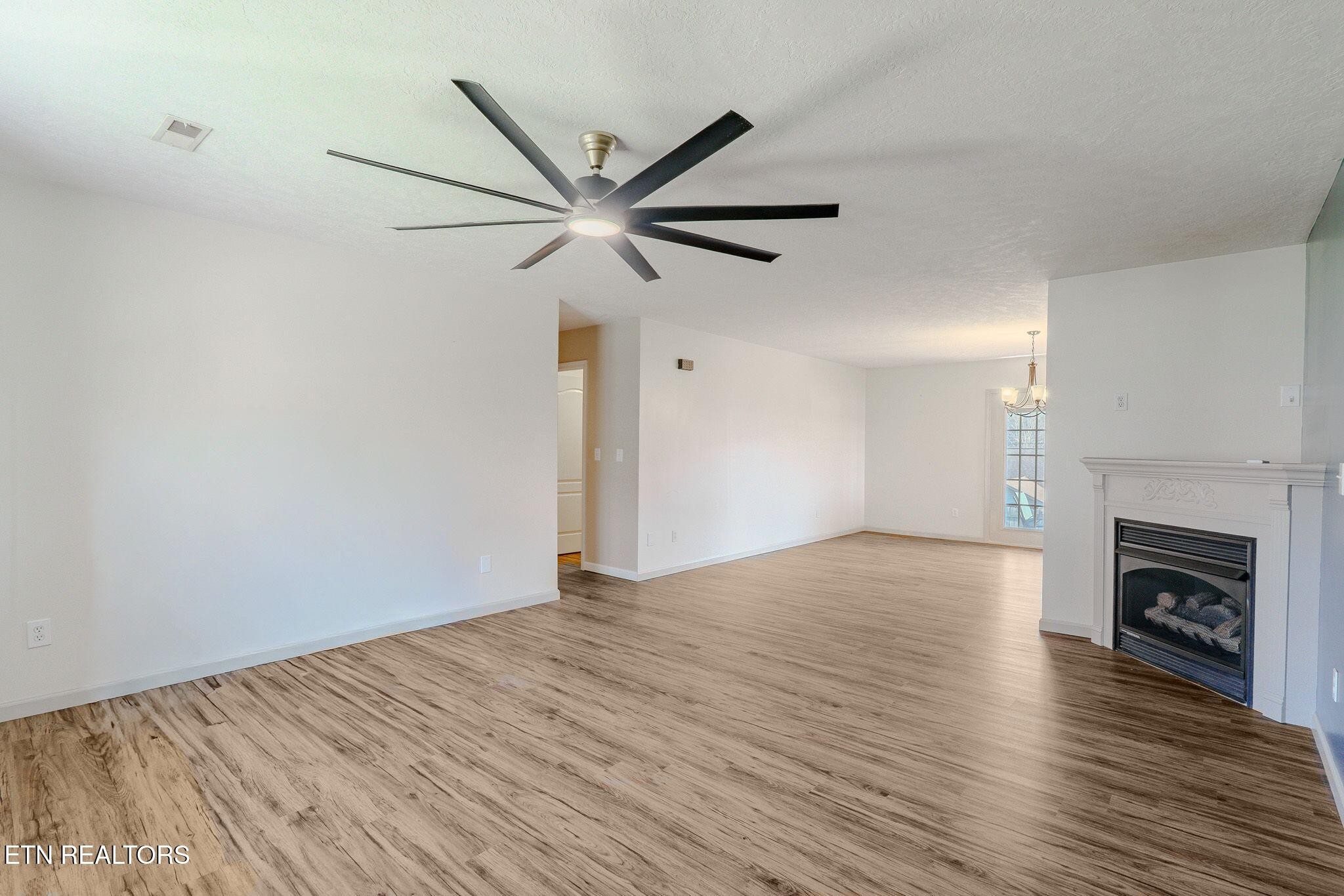 6622 Carina Lane Corryton, TN 37721 - Photo 6 of 30 a view of an empty room with wooden floor fireplace and a window