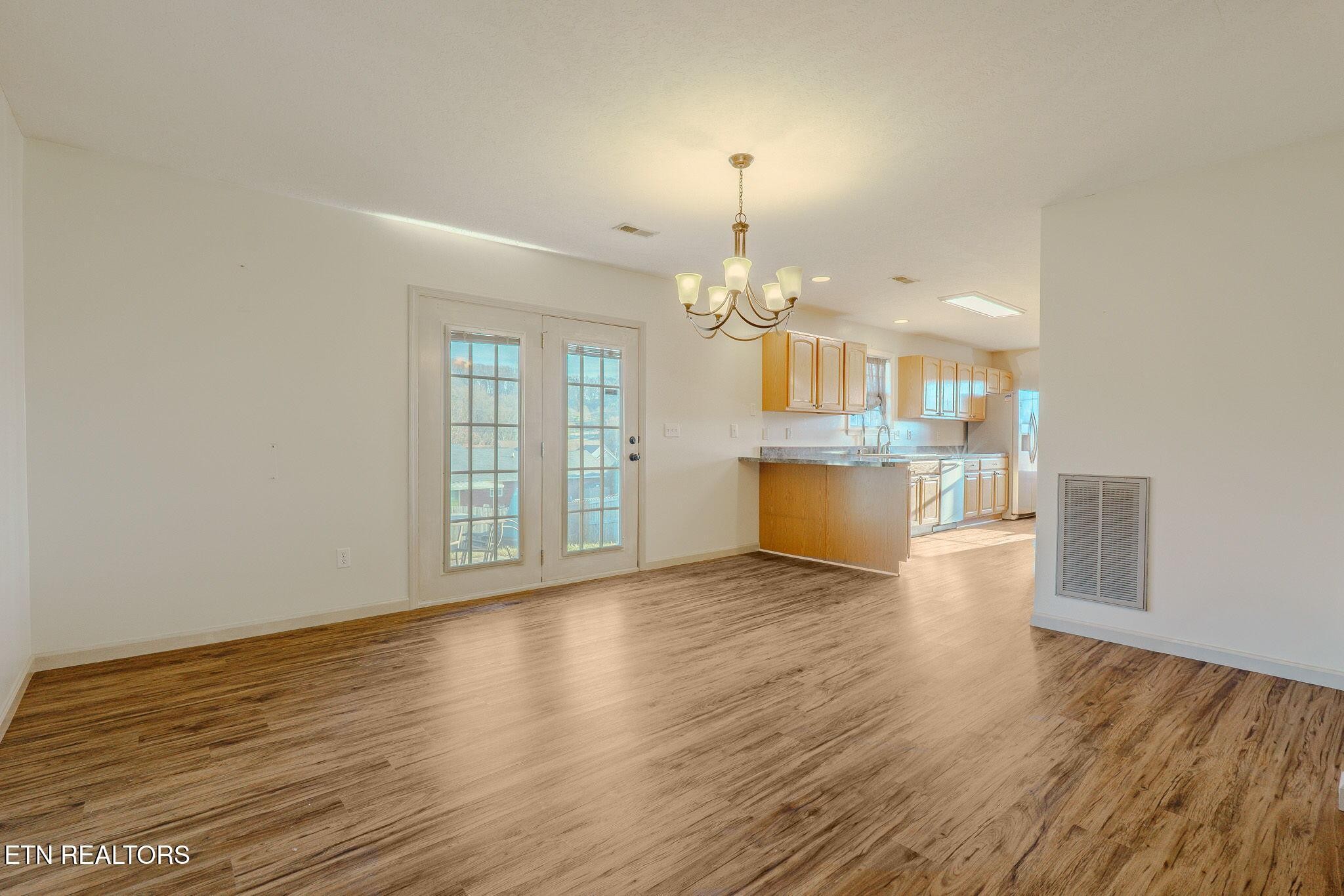 6622 Carina Lane Corryton, TN 37721 - Photo 9 of 30 a view of a room with wooden floor and kitchen view