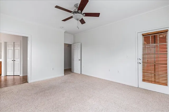 an empty room with a ceiling fan and window