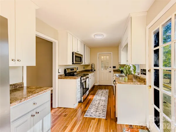 a kitchen with stainless steel appliances granite countertop a refrigerator a stove top oven a sink and dishwasher