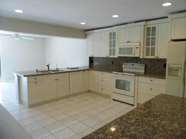 610 Southwest 17th Street Boca Raton, FL 33486 - Photo 2 of 49 a kitchen with white cabinets stainless steel appliances and sink