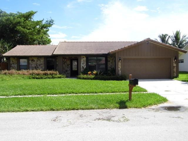 610 Southwest 17th Street Boca Raton, FL 33486 - Photo 3 of 49 a front view of a house with a garden and plants