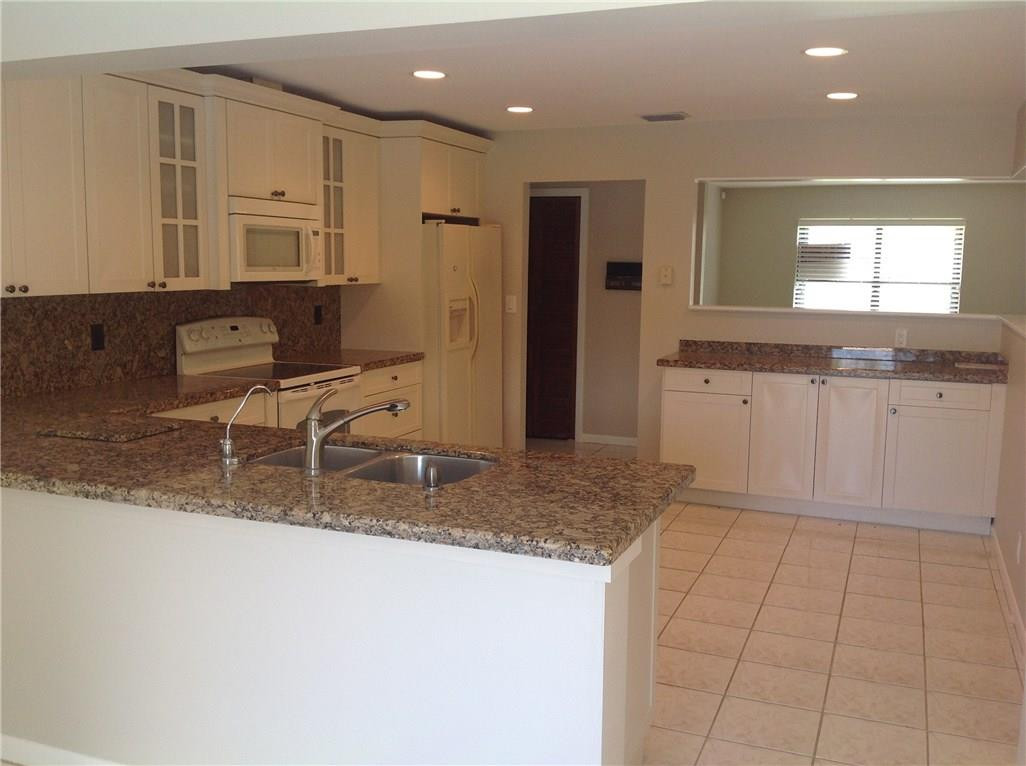 610 Southwest 17th Street Boca Raton, FL 33486 - Photo 31 of 49 a kitchen with stainless steel appliances granite countertop a sink and a granite counter tops