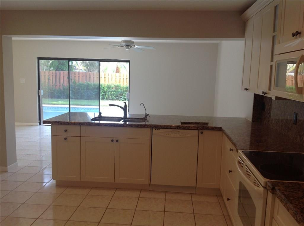 610 Southwest 17th Street Boca Raton, FL 33486 - Photo 36 of 49 a kitchen with granite countertop a refrigerator and a sink