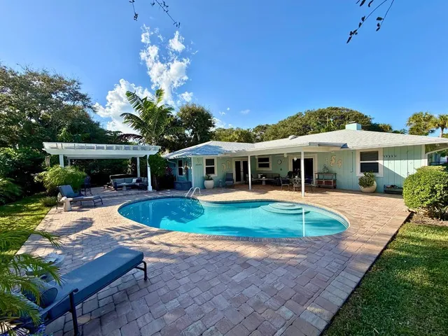 a view of a house with a yard patio and swimming pool