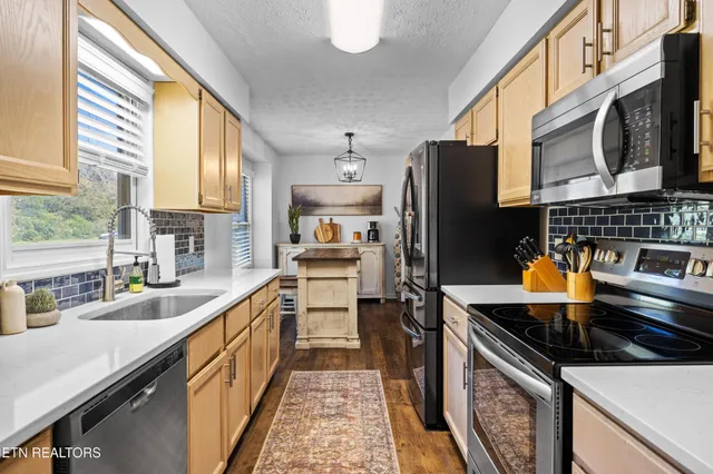 a kitchen with stainless steel appliances granite countertop a sink stove and refrigerator