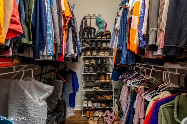 a view of walk in closet with clothes and shoes