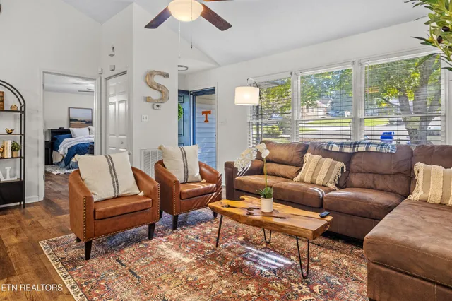 a living room with furniture wooden floor and a large window