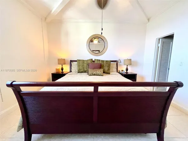 a bedroom with a bed and a lamp on dresser